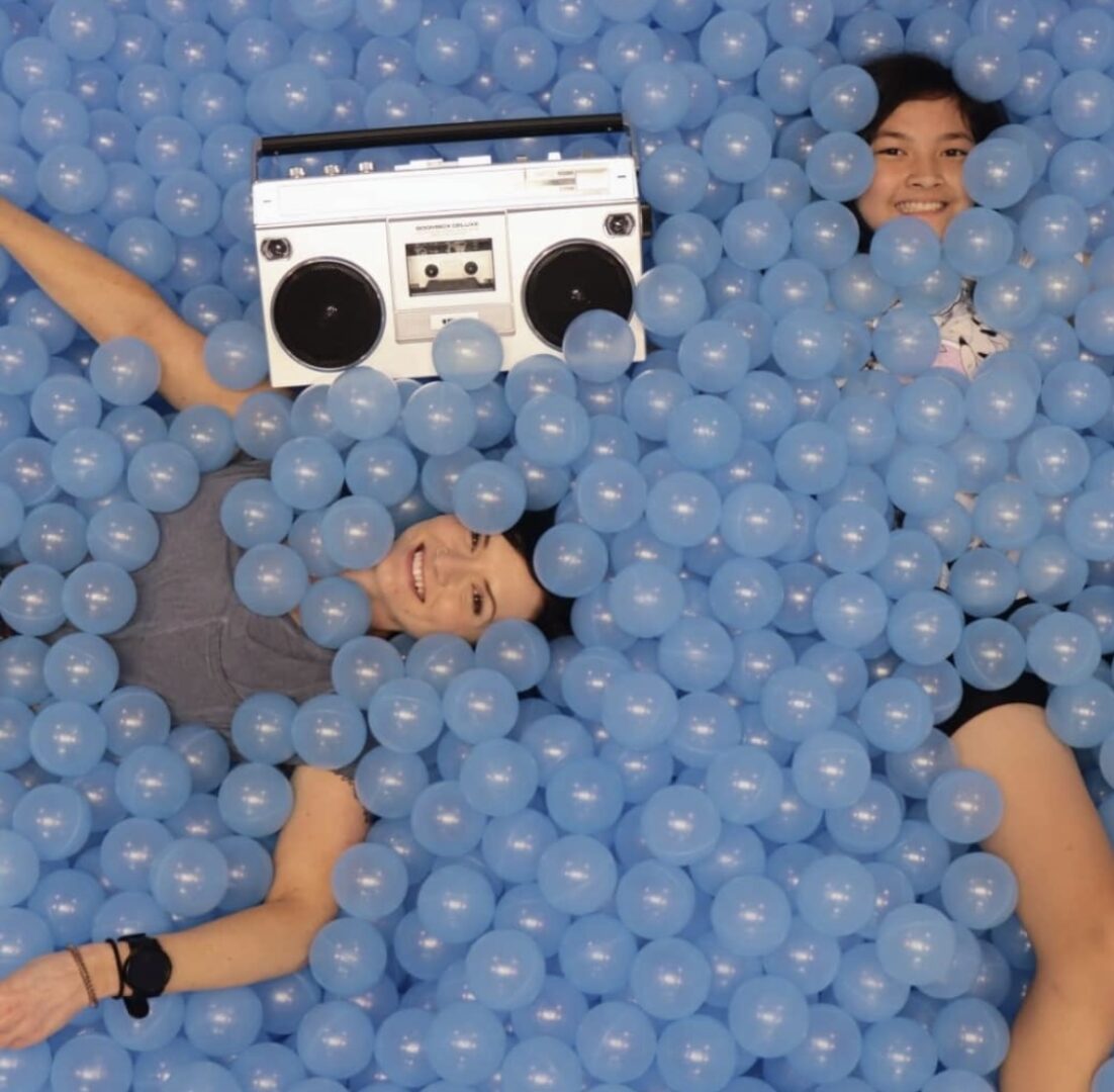 Two girls on a blue ball pit